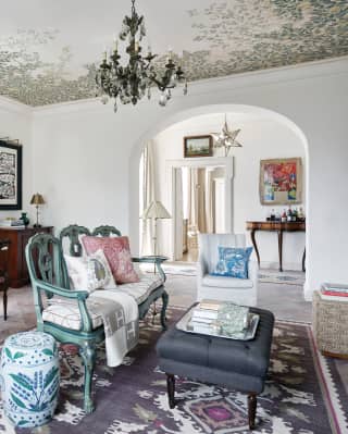 The chic living area, with upholstered eighteenth century Neapolitan chairs, Venetian settee, tiled floors and tapestry rug.