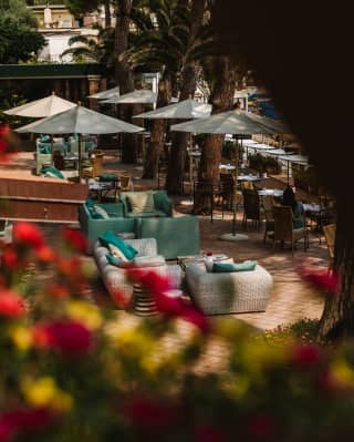 With soft seating, tables and parasols, the terrace bar promotes relaxation on every level, seen through trees from above.