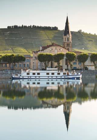 Crociera fluviale di lusso mentre oltrepassa un piccolo villaggio in Alsazia, Francia