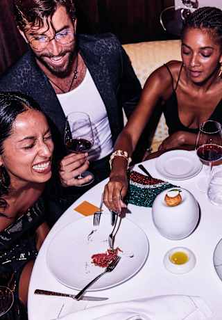 A group of friends dining, drinking and laughing around the table