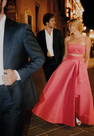 A dressed up couple walking on the Tormina street in the evening