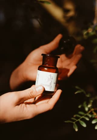 two hands holding a essential oil bottle 