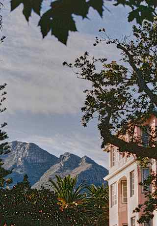 The contours and ridges of the mountain ranges create dramatic scenery behind the manicured elegance of the hotel.