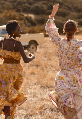 Duas mulheres correndo alegremente pelas savanas