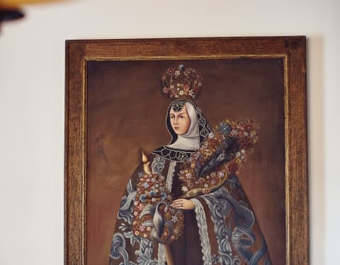 Close-up of a portrait of a regal woman wearing a cloak and floral crown