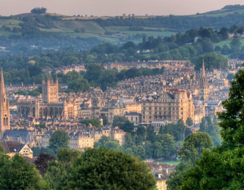 Hilltop view of the World Heritage City of Bath, capturing the sunrise glow on the Abbey, church spires and famous terraces.