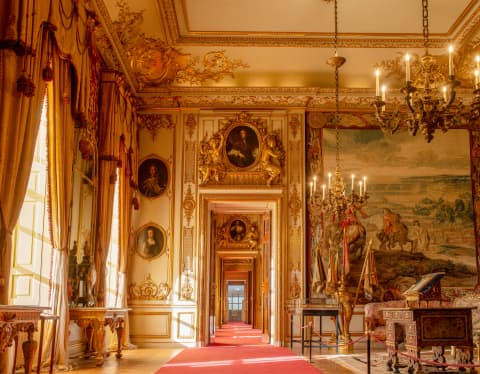 Sun pouring through windows of Blenheim Palace's State Rooms illuminates the gilded frames, chandeliers and ornate cornices.