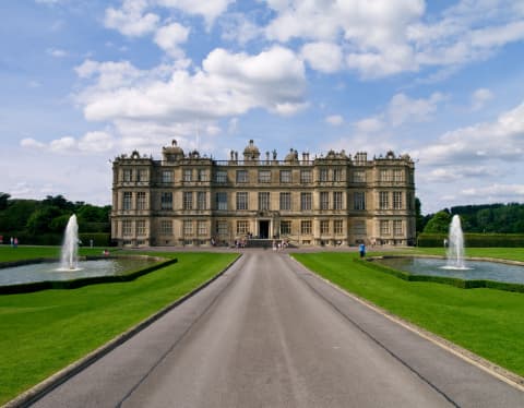 A long driveway, flanked by fountain pools, leads to the symmetrical, Elizabethan prodigy-style Longleat House in Wiltshire.
