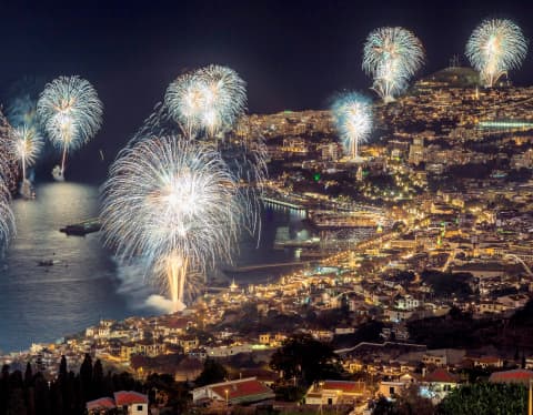 A collection of fireworks lighting up the night sky over Funchal Bay