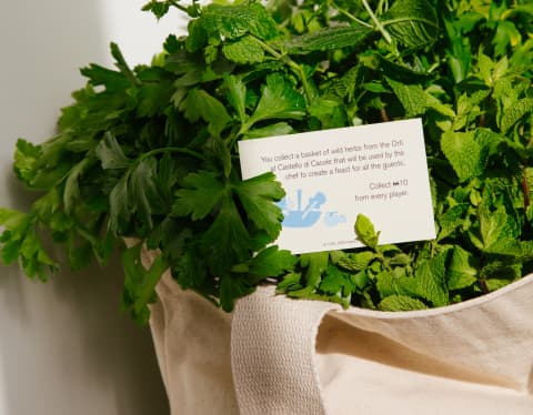 A card tucked into a jute bag filled with greens suggests the reader takes a walk in the vegetable gardens to gather herbs.