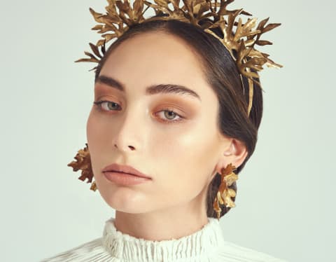 A model wears a handcrafted tiara and earrings in tumbaga, inspired by nature and designed by Mexican jewellers Romo Herrera.
