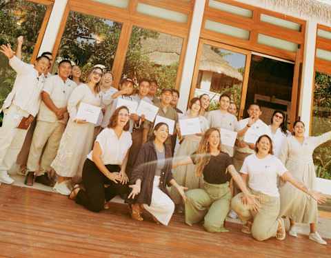 Angled image of a group of Maroma staff with 'Ocean Guardians' certificates following training by Parley for the Oceans.