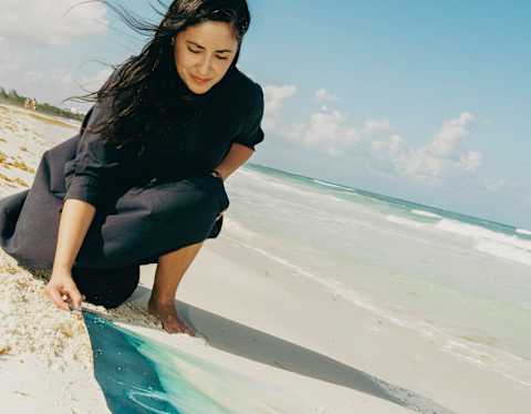 Celebrating the collaboration between Belmond and Parley, artist Paola Davila lays a cyanotype on the sand by the ocean.