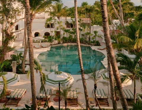 A ring of palms creates an oasis feel at Maroma's pool, which sits like a turquoise jewel in cream stone, seen from above.