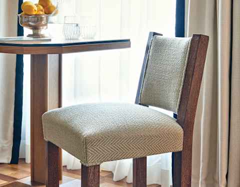 Close-up of a herringbone Italian knit chair at a table with a lemon centrepiece