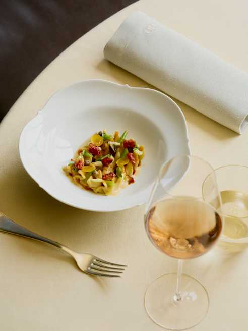 Fisherman's wheel-shaped pasta with tuna cream, capers, cherry tomatoes and monkfish sauce, served with a light rosé wine.