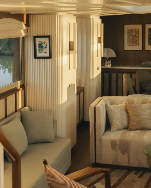 The elegant, striated cream walls of the lounge catch ripples of sunlight from windows opposite, bathing the room in warmth.