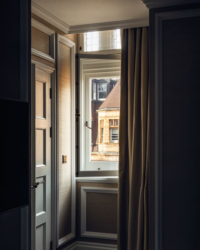 An open window offers a glimpse of a hexagonal Pont Street turret; marking the roofline on the opposite side of the street