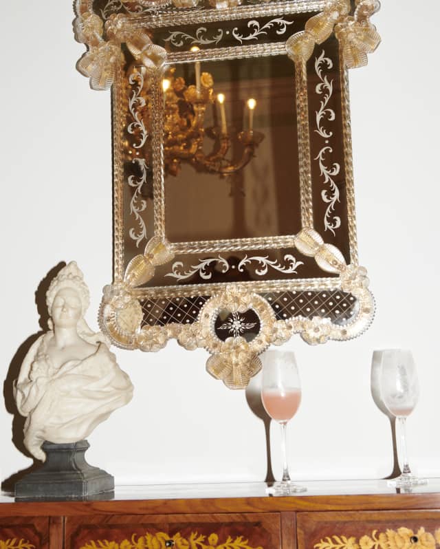 Two half-drunk champagne glasses of the Cipriani’s famed Bellinis are left on a sideboard next to a marble bust of a goddess