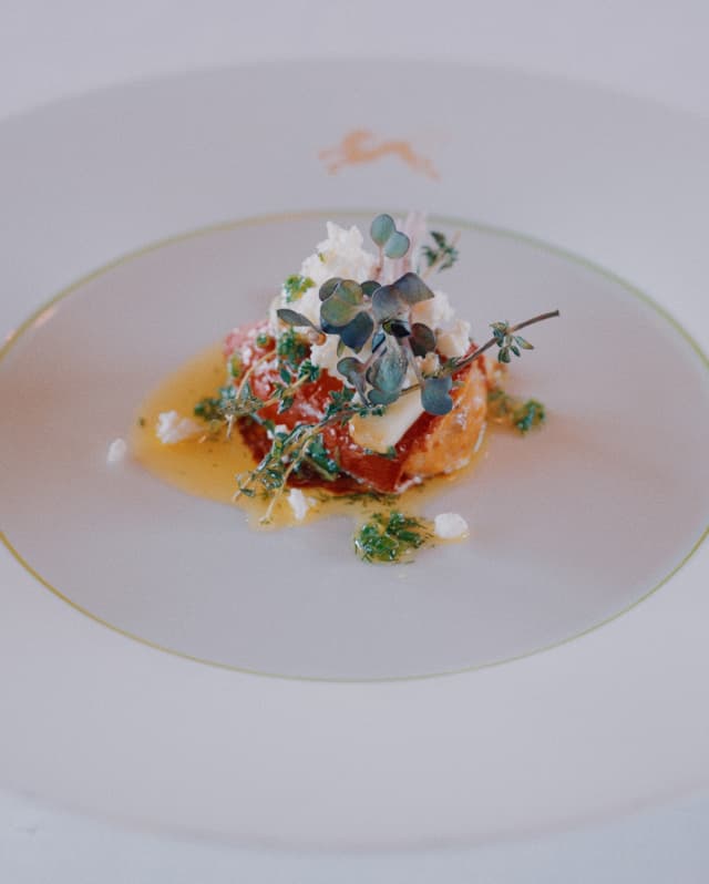 Looking at a plate created by André Chiang with a piece of lobster, topped with herbs and sitting in a buttery fish liquor.