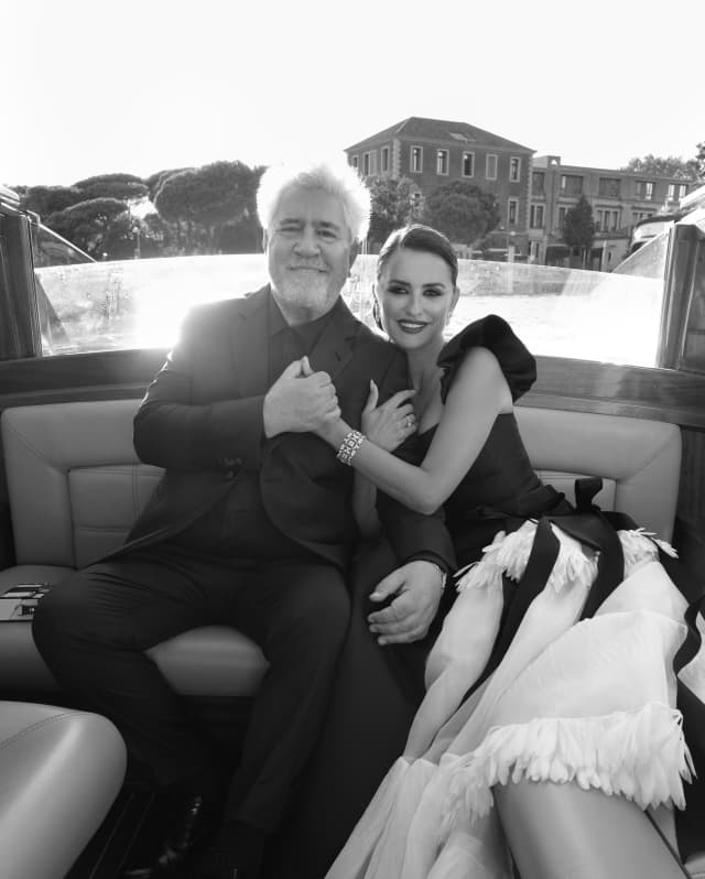 Black and white image of actress Penelope Cruz and film director, Pedro Almodóvar, dressed in style in a water taxi.