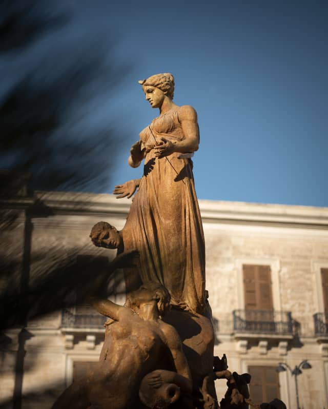 Sun glows on the fountain statue of Diana, also know as the fountain of Artemis, in Piazza Archimede in Syracuse.