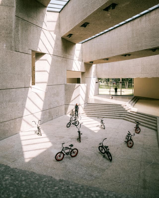 Eight parked pushbikes feature in an art exhibition in a concrete hall with skylights at the Museo Tamayo Arte Contemporáneo.