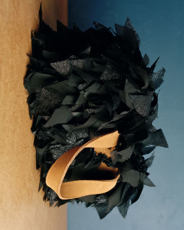 Close-up of a shopper bag in repurposed knotted black silk with tan leather strap, designed by Laani Raani.