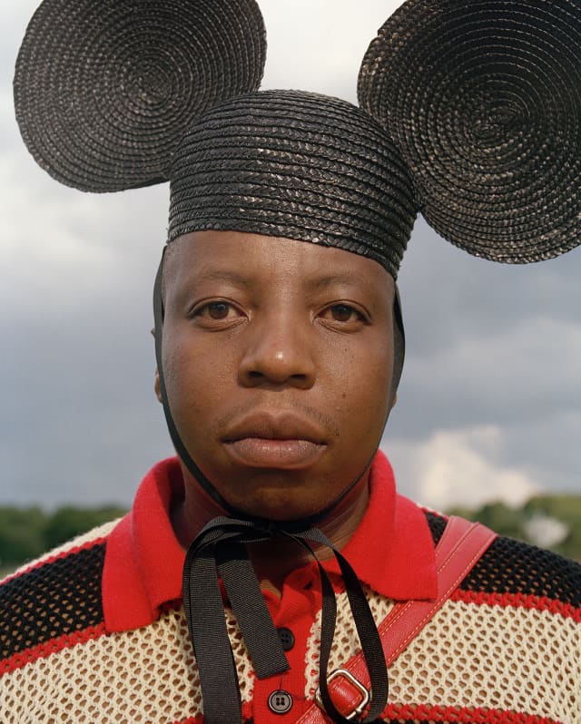 Designer Wanda Lephoto wears his playful rattan creation of a black hat with a tie and Mickey Mouse-like ears on either side.