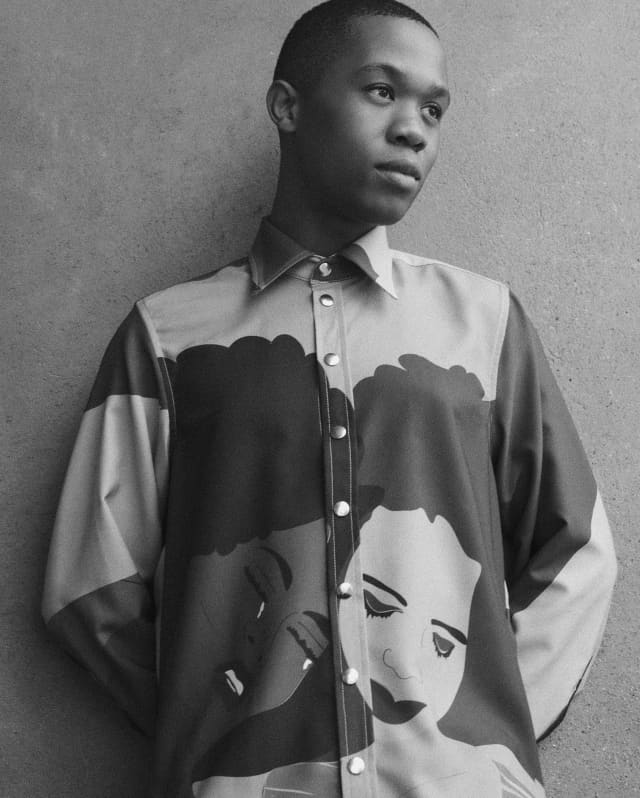 Thebe Magugu, photographed by Jodi Bieber in black and white, wears a high-buttoned garment with his Girl Seeks Girl design.