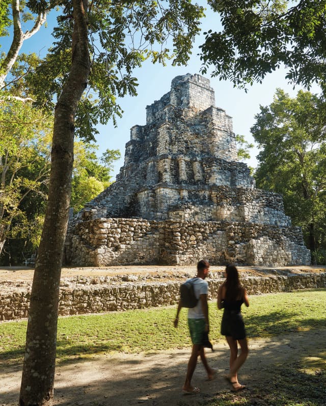 a couple walking by the Mayan ruins of Muyil