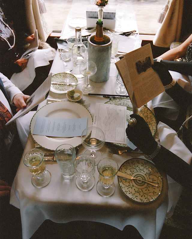 Looking down on a dining table busy with glasses and crockery as guests peruse the menu and their Murder Mystery evidence.