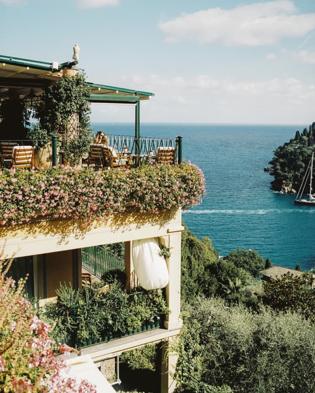 A stack of private terraces, dripping with trailing, flowering plants, soak in the views of the incredible Portofino coast.