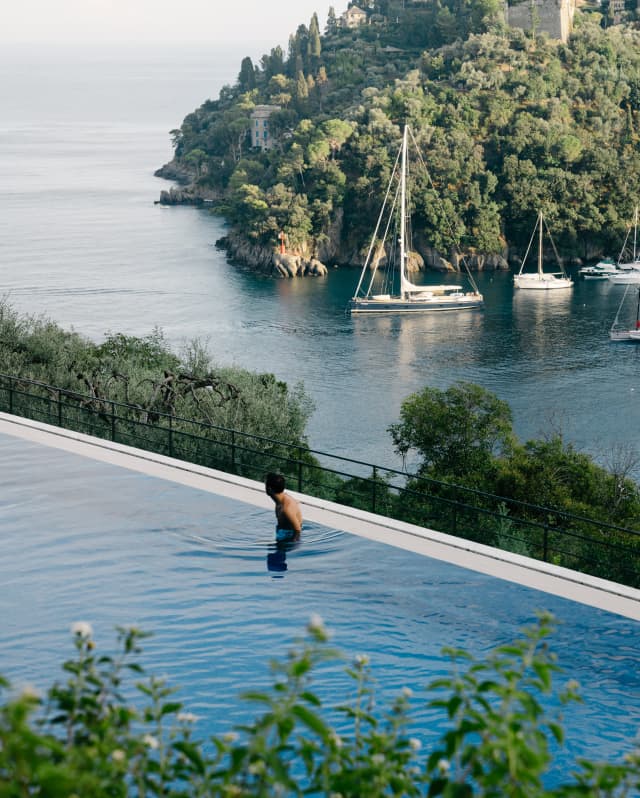 A man looks out over Portofino Bay and the immensity of the Mediterranean beyond from the edge of the hotel's pool