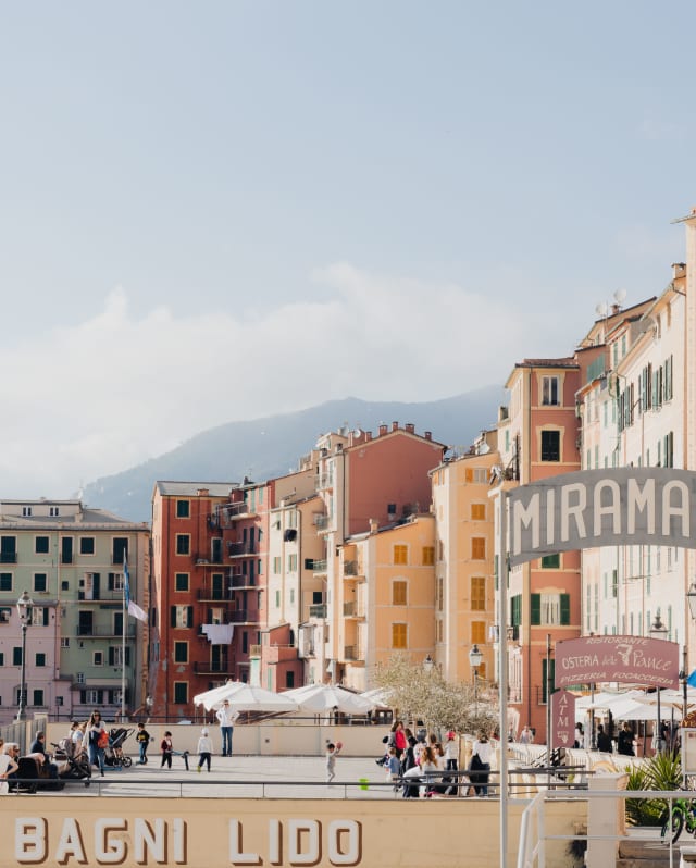 An uneven terrace of 4, 5 and 6 storeys in palest pinks, yellows, greens and reds feel joyful as they cluster at the harbour front