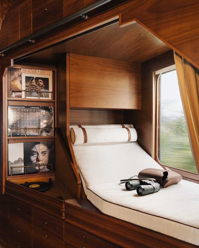 A selection of vinyl is kept neat in shelves adjacent to a window-side daybed where binoculars rest on the white mattress.