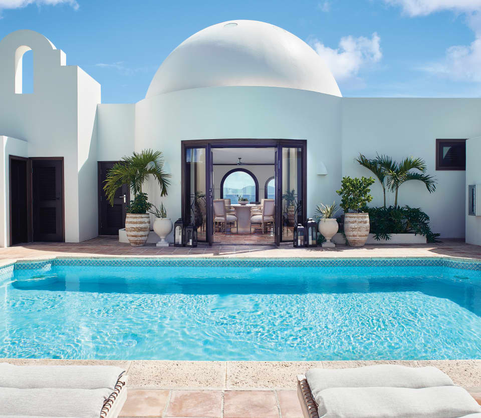 Large square pool in a sunny courtyard with a domed circular room beyond