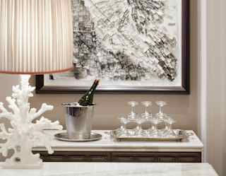 Champagne in a cooler next to a pyramid of coupe glasses